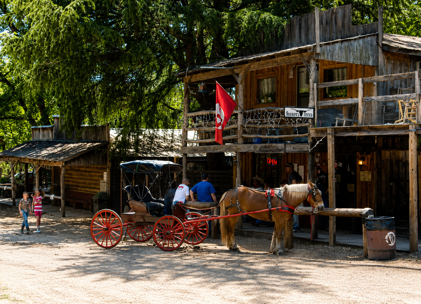 Horse-drawn buggy with red wheels outside the Sheriff's Office on Main Street