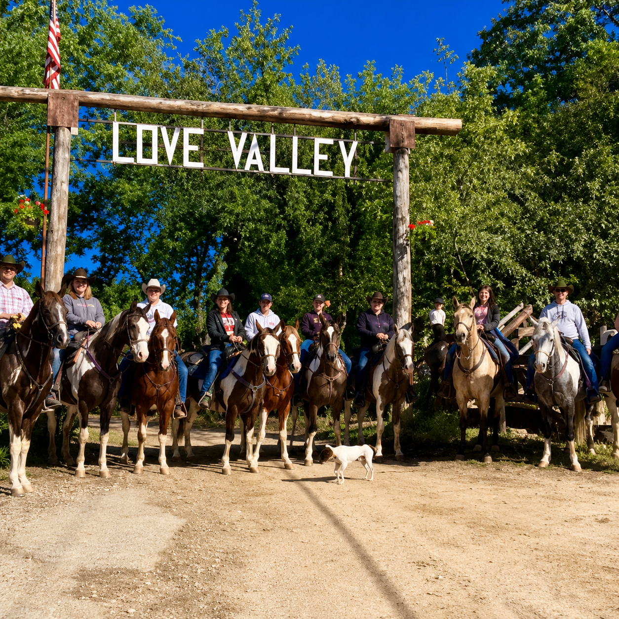 Group of riders on horseback lined up under the Love Valley entrance archway